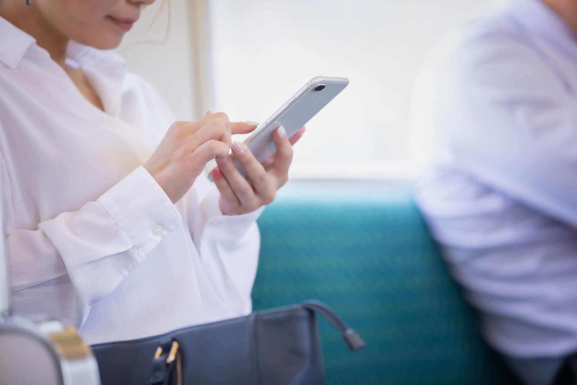 電車内でスマホを操作する女性